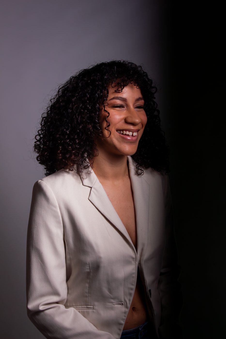 Hannah Kerchhoff laughing in a cream blazer